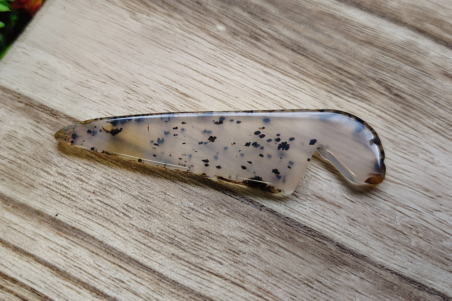 Decorative stone with black speckles on a wooden surface