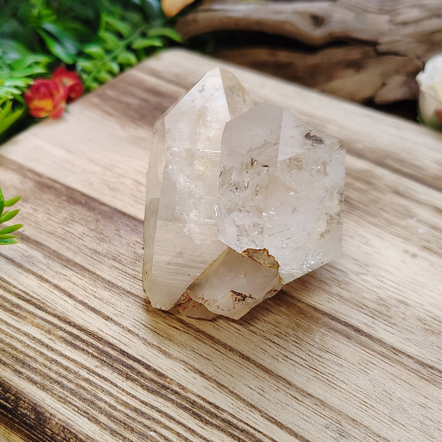 Crystal on a wooden platform with greenery and flowers in the background
