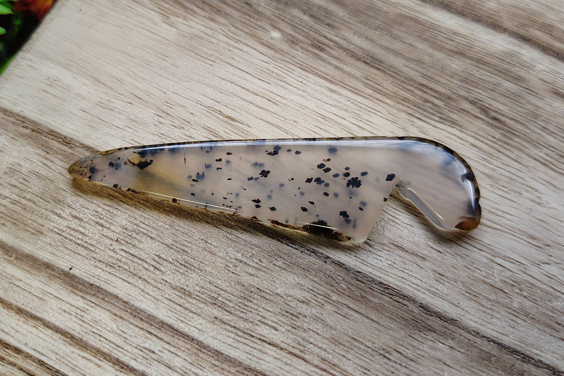 Decorative stone with black speckles on a wooden surface