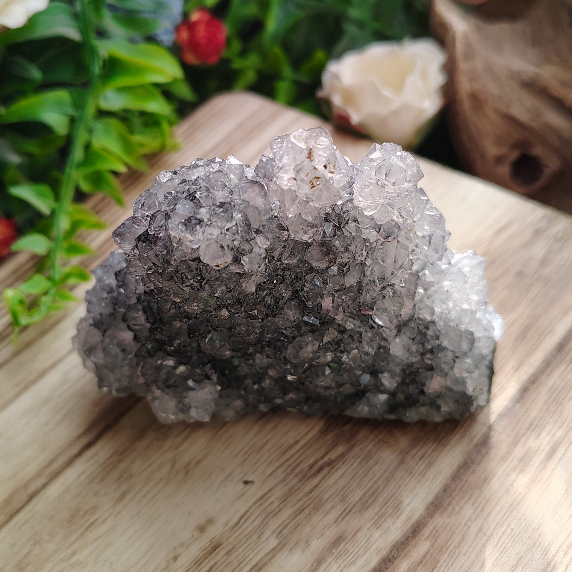 Mineral specimen on a wooden block with greenery