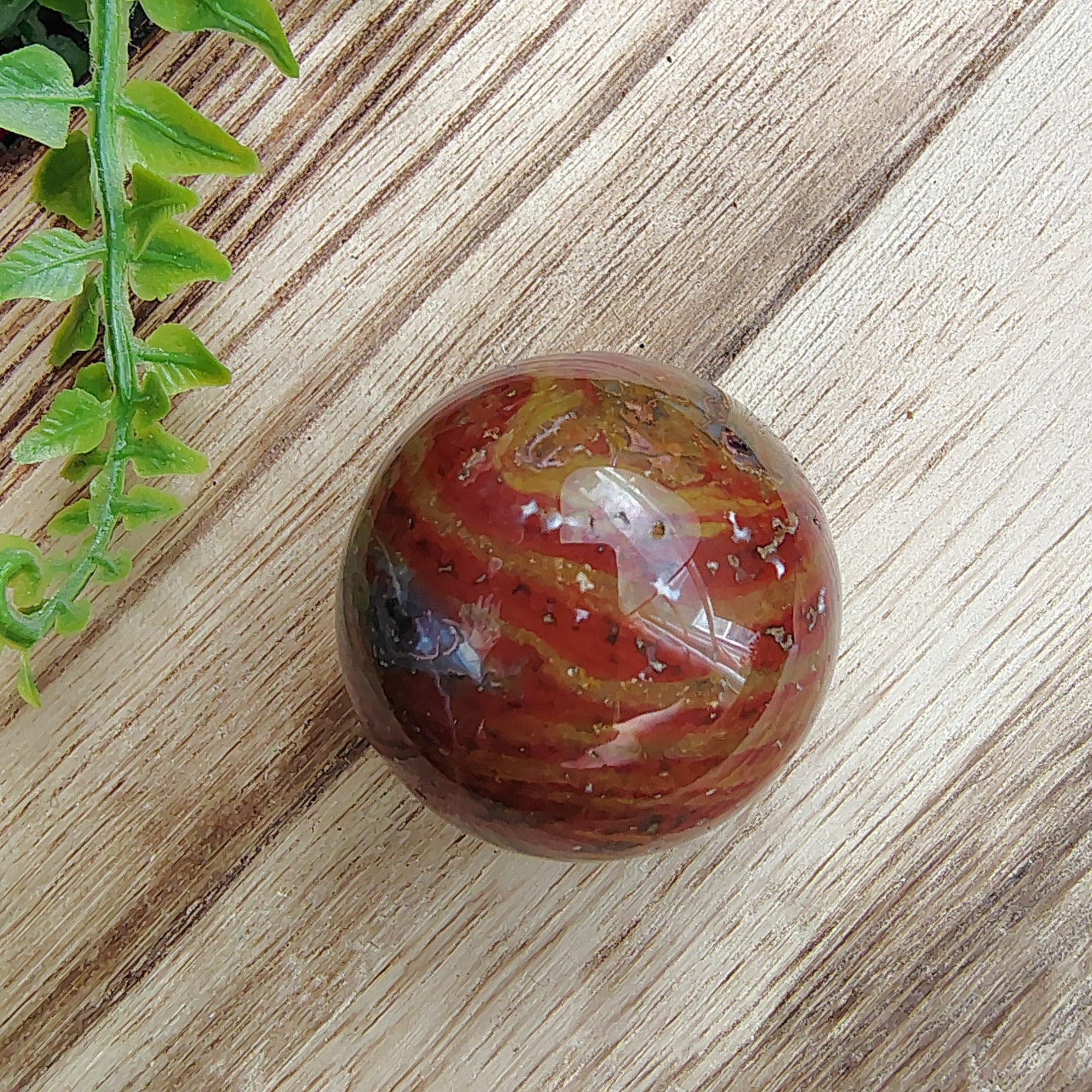 Marbled stone on a wooden block with flowers and greenery in the background