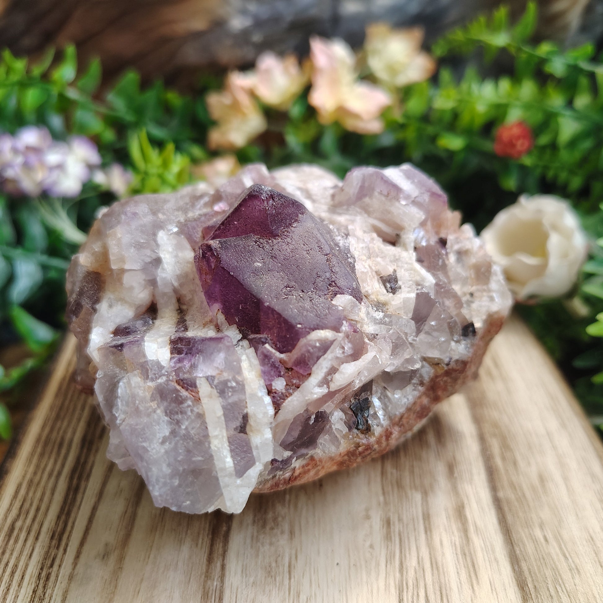 Crystal formation on a wooden surface with greenery in the background