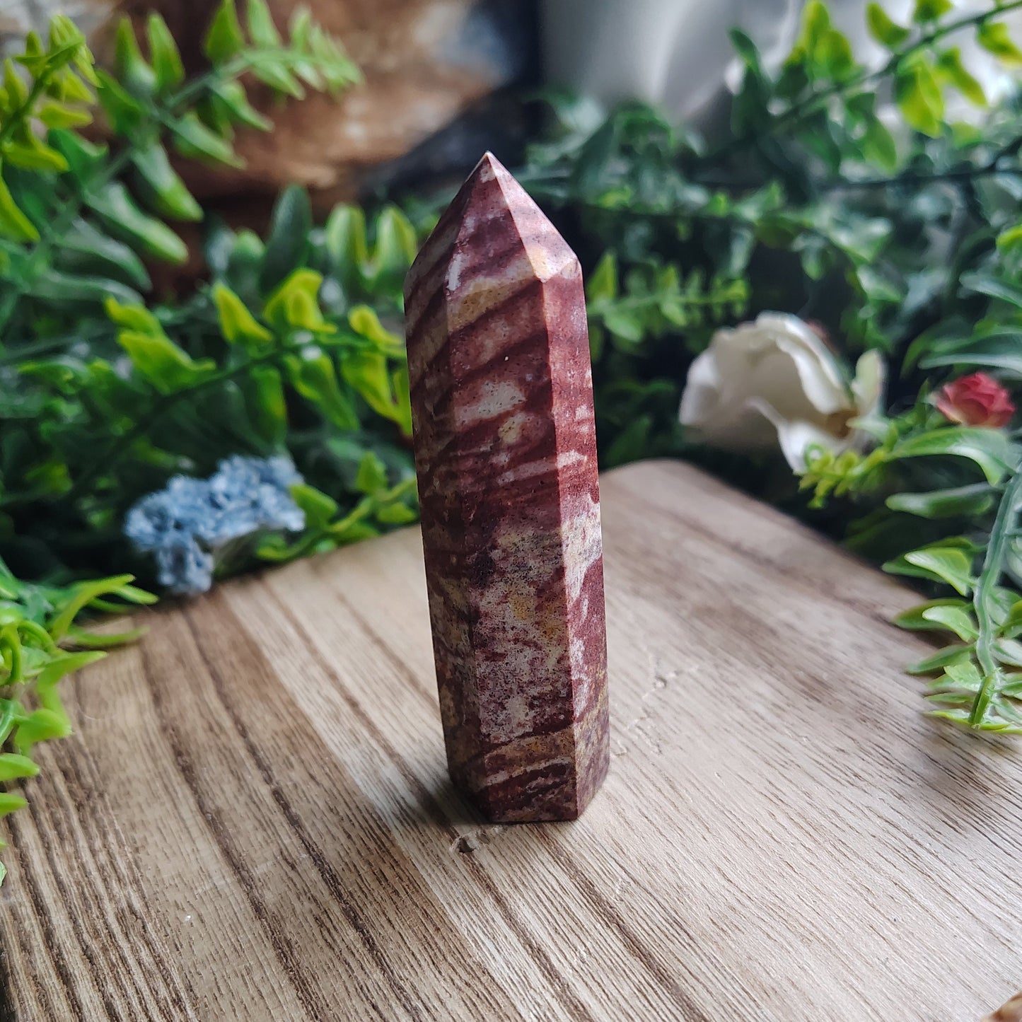 Crystal on a wooden surface with greenery in the background