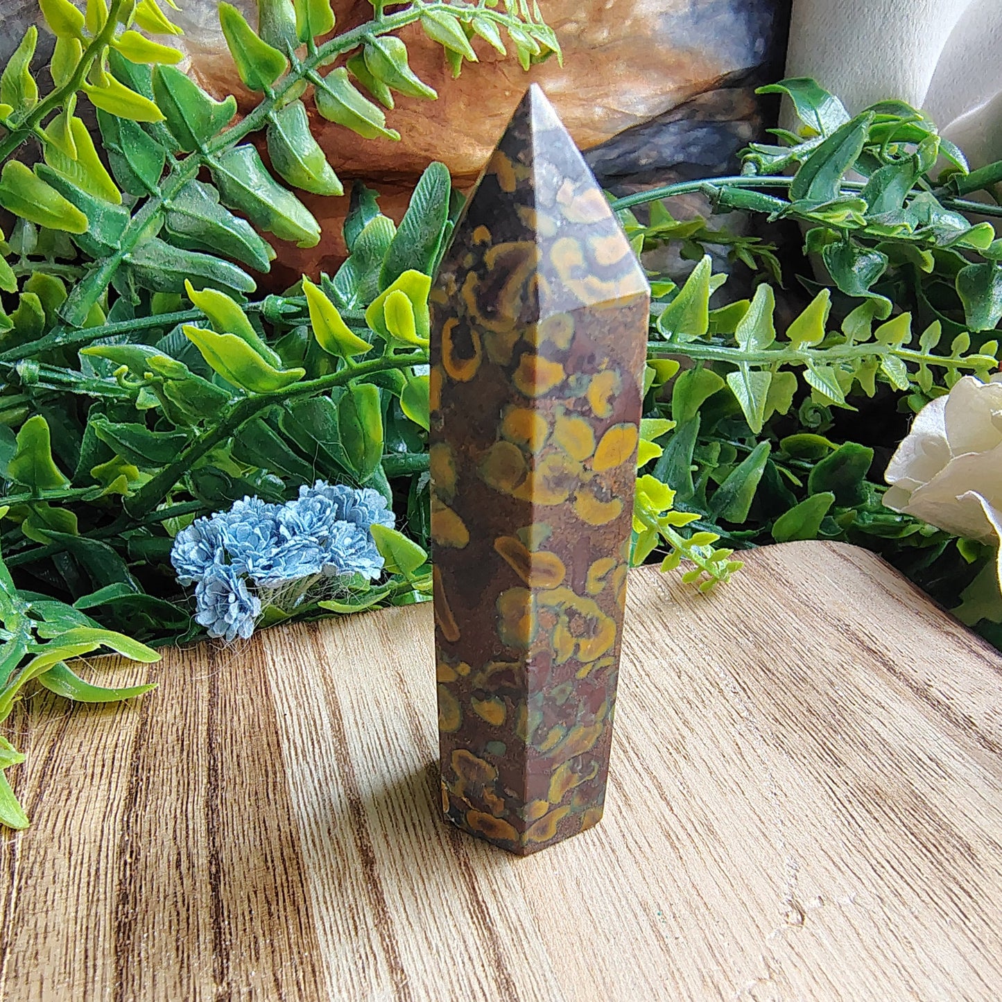 Decorative crystal on a wooden surface with greenery