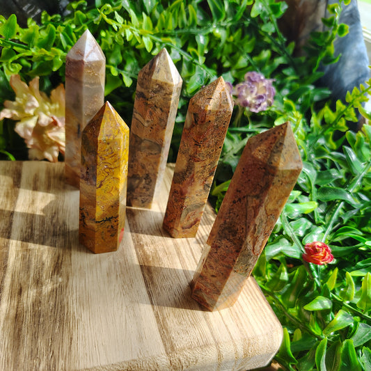 Wooden crystal grid on a wooden surface with plants in the background